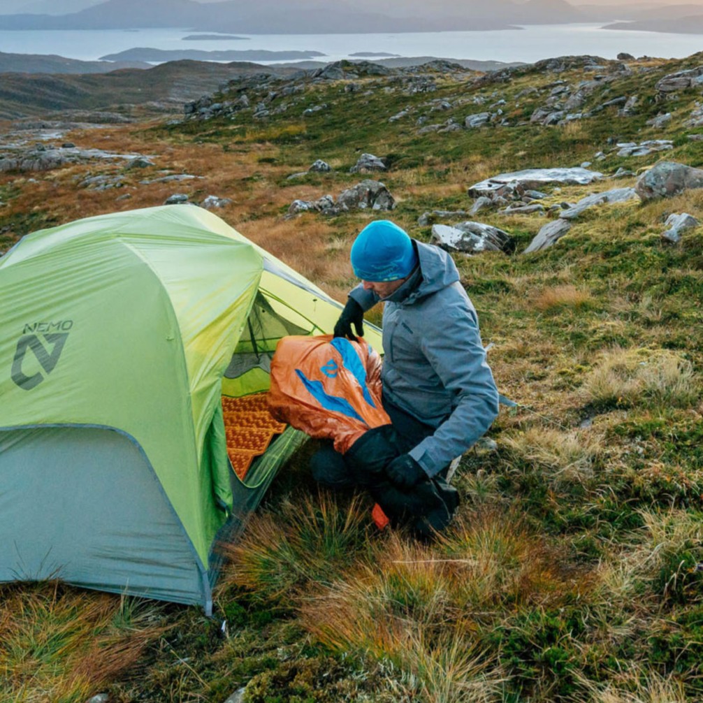 Backpacker setting up tent in wilderness